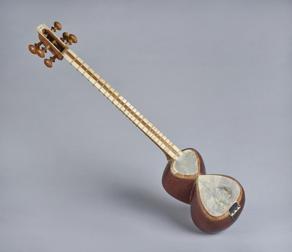 <p>stringed instrument with long neck and pear shape. has a distinct hourglass body. typically has 6 strings.</p>