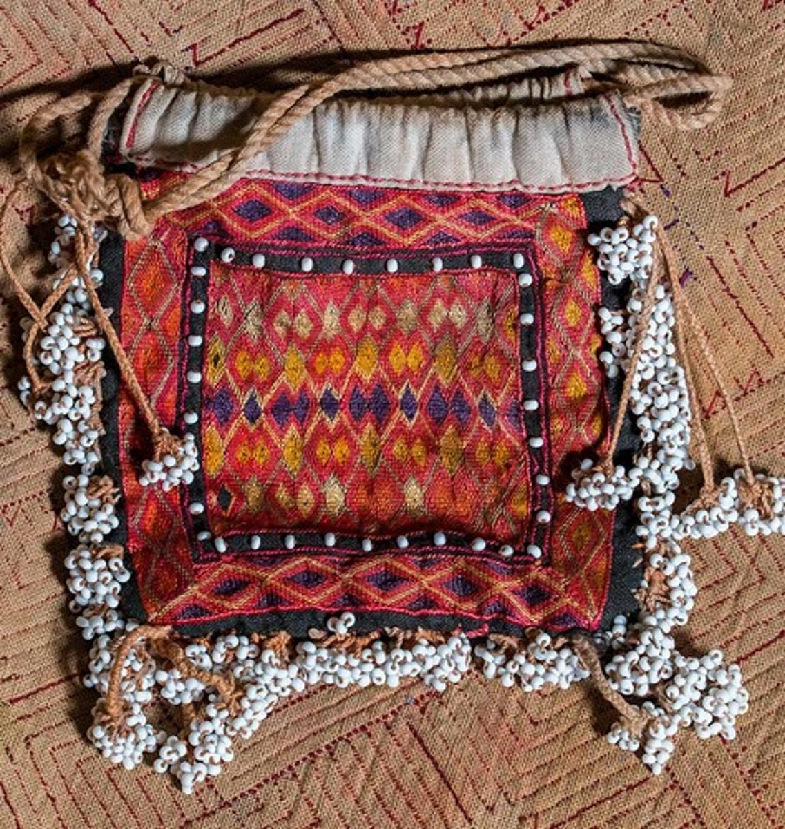 <p>A coverlet or shawl of wool, knitted or crocheted in colorful geometric designs.</p>