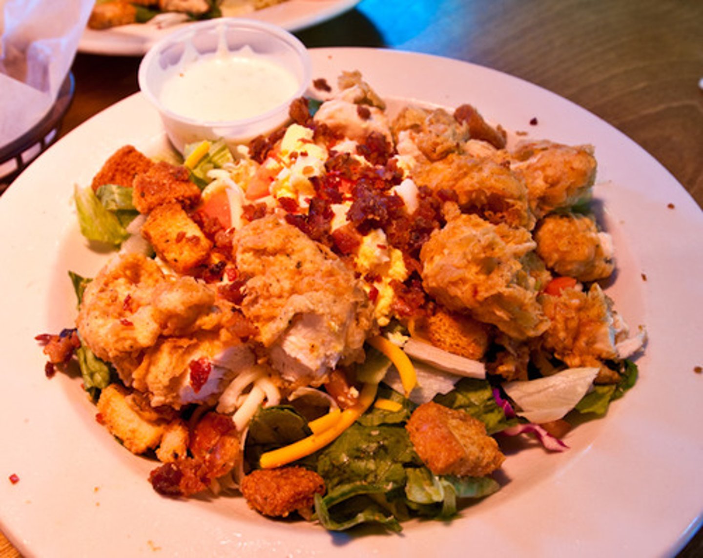 <p>salad greens topped with 4 hot, crisp chicken critters, jack and cheddar cheese, tomato, back and eggs (NO CROUTONS-CRITTERS MAKE IT CRUNCHY!)<br>Choice of dressing on the side<br>frozen/chilled large bowl</p>