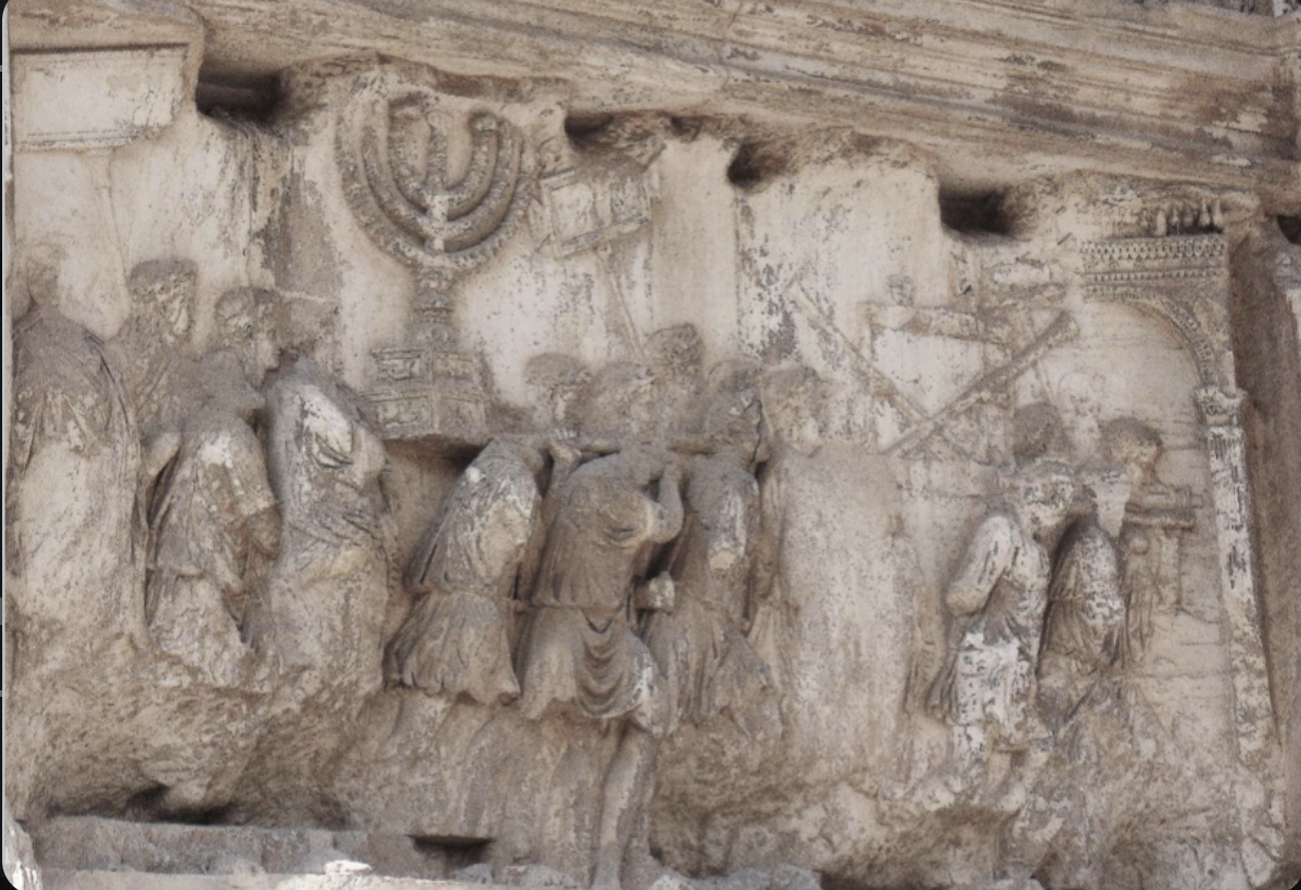 Flavian carving of men running with trumpets as a celebration march. they're all walking toward an arch, w/ very deep carvings (characteristics of flavian art). 