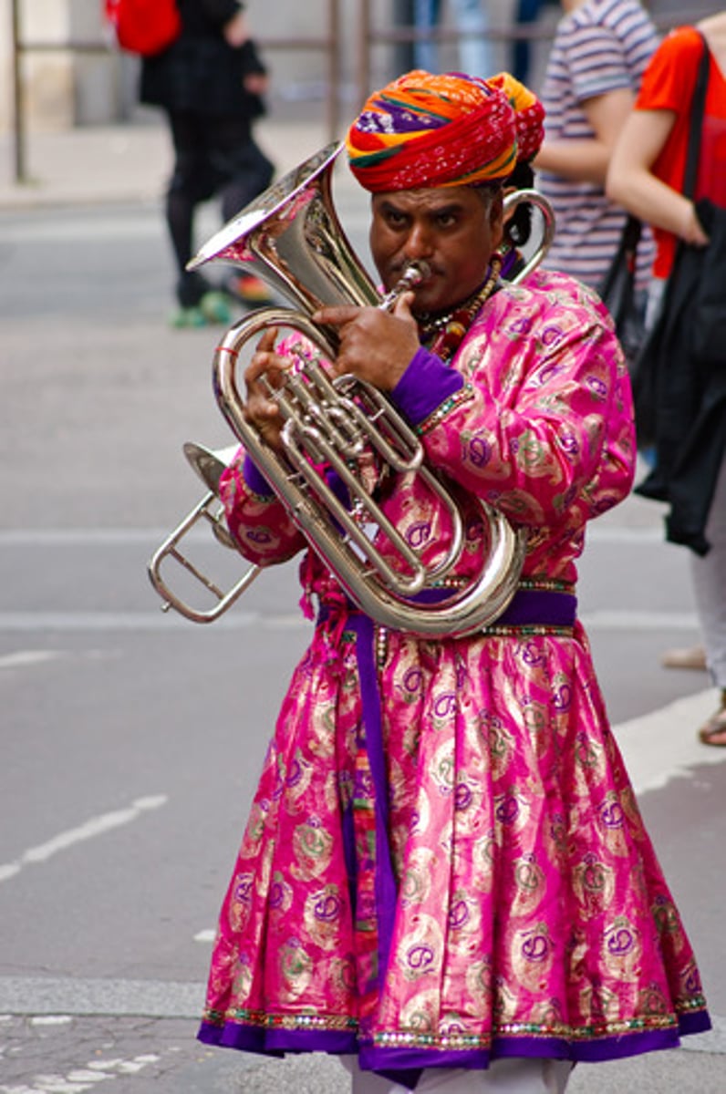 <p>noun - A sounding of trumpets or other brass instruments</p><p>OR</p><p>Any showy display.</p>