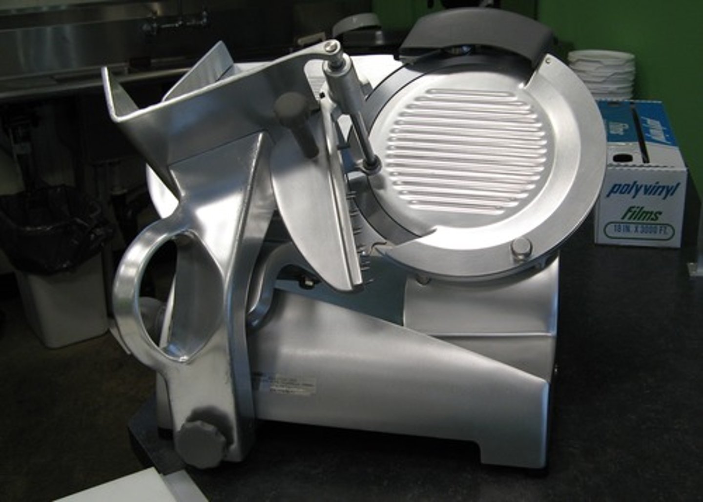 <p>Most have a slanted circular blade. Food either passes through the machine automatically, or a cook pushes a hopper holding the product along a carriage into the blade. The thickness of the slicer is set by increasing and decreasing the distance between the guide plate and the blade.</p>