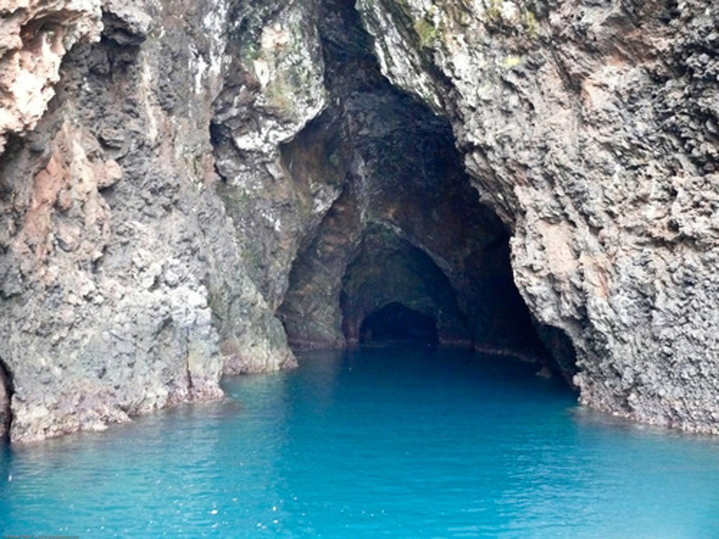 <p>the extended cracks and hollows at the base of a cliff</p>