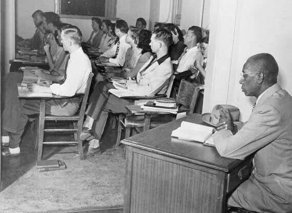 This photo shows a segregated classroom in 1948 at the University of Oklahoma, where an African American student is seated as single desk, apart from his white classmates.