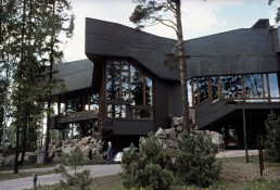 <p>big granite rocks coming from ground (base of building), tall+vertical trees and verticals made from wood with copper canopy at top of building (wears green), when inside, feels outside</p>