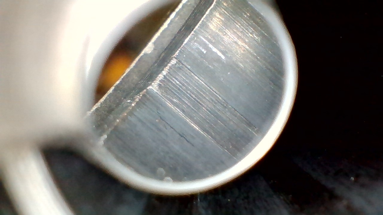 <p>What type of machining likely created the continuous lines running parallel to the rifling (mostly on the lands) seen in this barrel?</p>