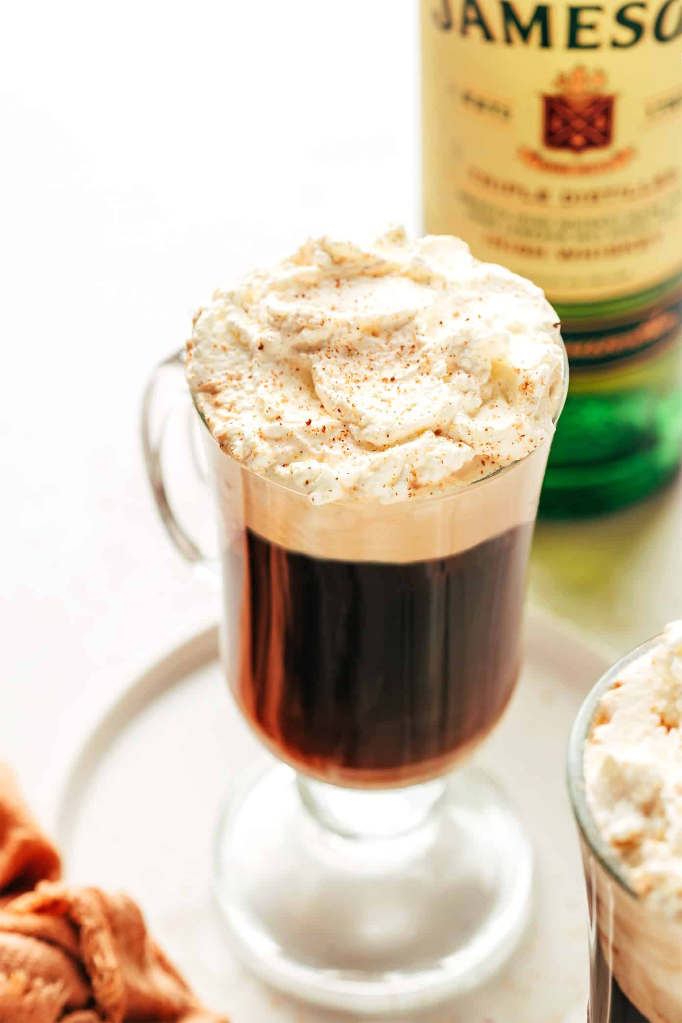 <p>hot, 1.5 oz Irish whiskey, 0.5 oz sugar, top with hot coffee, optional 1 oz heavy cream, top w/ whipped cream, served in a mug</p>