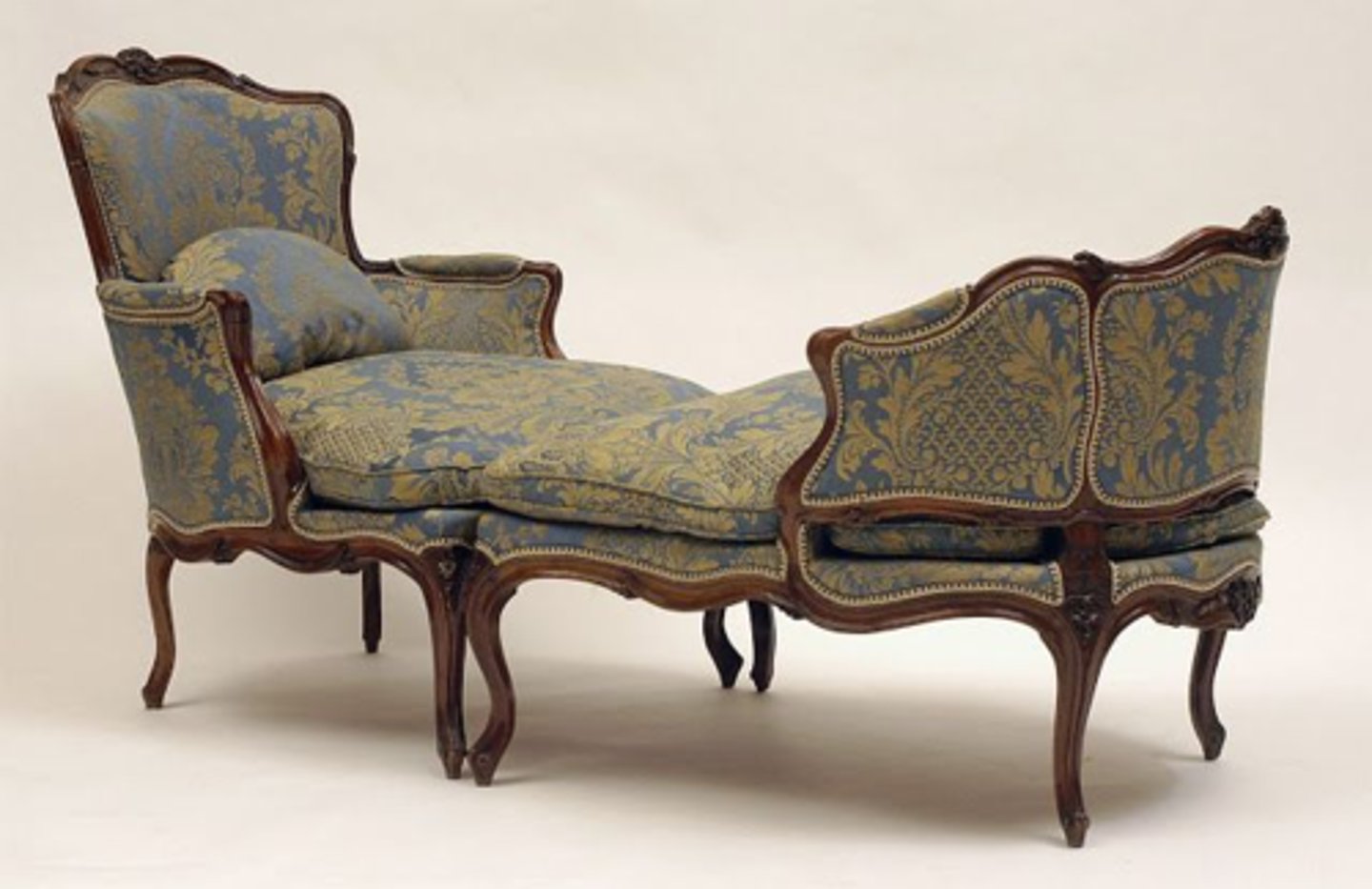 <p>French Rococo (Louis XV)</p><p>Two-piece French rounded back upholstered chair with a separate elongated footstool.</p>