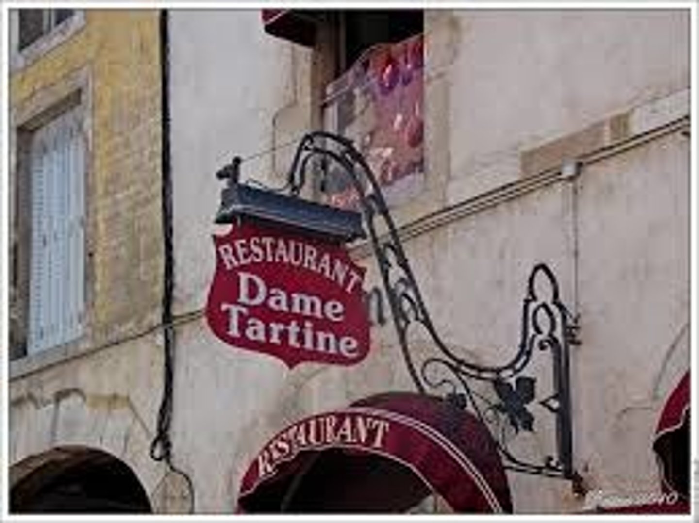 <p>marque placée sur la façade d'un établissemet commercial, panneau</p>