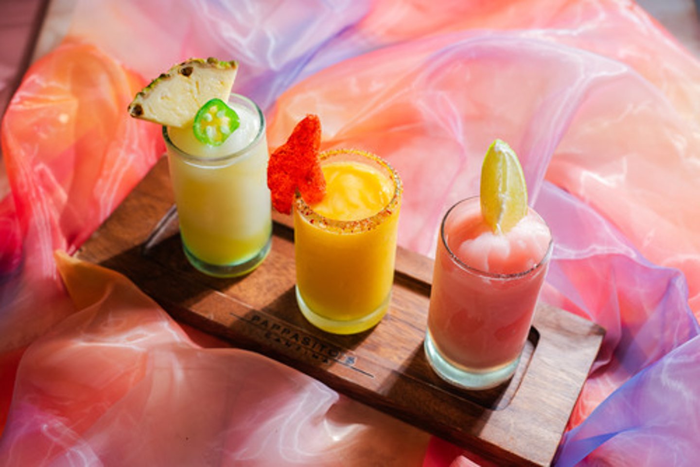 <p>Frozen Margarita Flight</p><p>Flavors:</p><p>- Roasted Piña Serrano</p><p>- Mango Chile</p><p>- Watermelon</p><p>Garnish:</p><p>- Jalapeno slice and chile salt</p><p>- Lime wheel and chile salt</p><p>- Watermelon wedge</p><p>Flavor profile: Fruity and frozen</p><p>Selling description: Our traditional frozen margarita in flavors of Watermelon, Mango Chile and Roasted Piña Serrano.</p><p>** Not available at airport locations.</p>