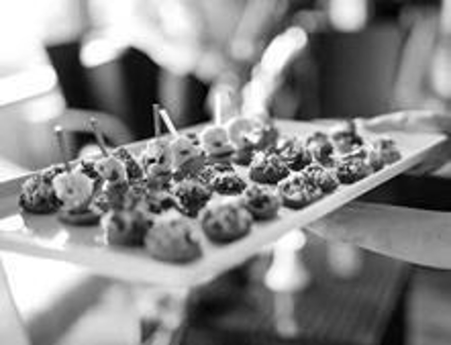 <p>Waiting staff circulates finger foods through the banquet room on large platters.</p>