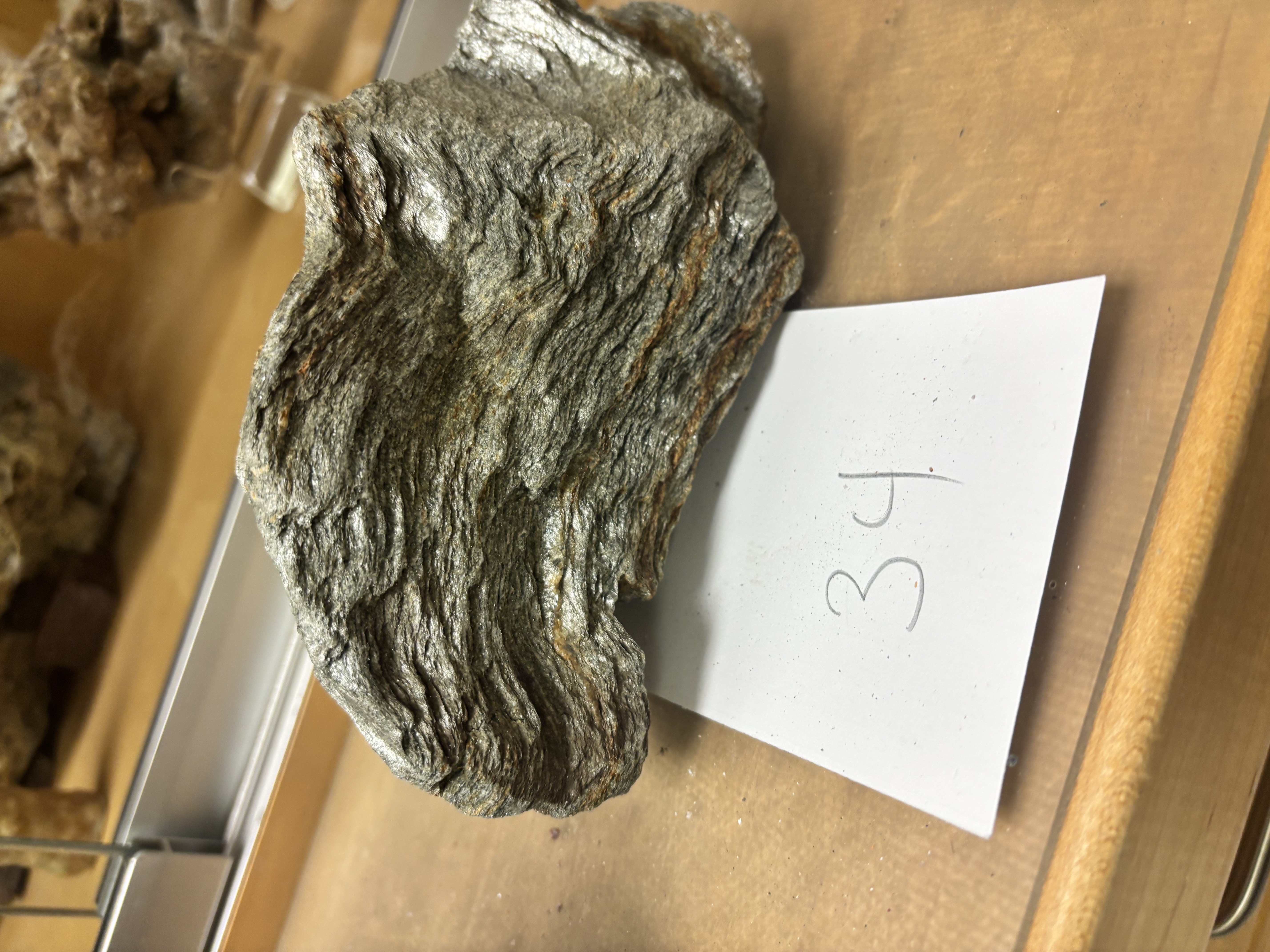 <p>Foliated metamorphic rock; silky or glossy sheen; wavy mica layers; intermediate between slate and schist.</p>