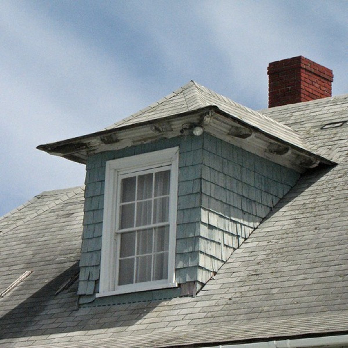 <p>a vertical window in a projection built out on a sloping roof</p>