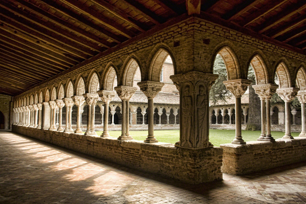 <p>An open courtyard that connects the buildings of a monastery through a covered walkway.</p>