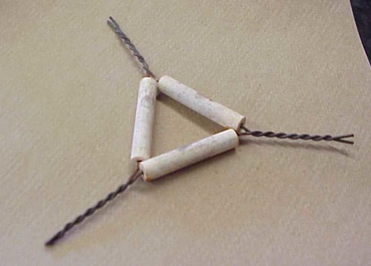 <p>wire frame with porcelain supports; used to support a crucible</p>