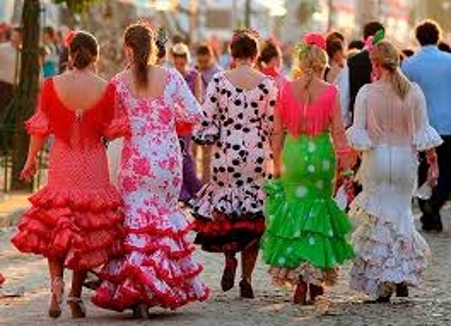 <p>Bright, colorful flamenco style (gypsy) dresses worn by the women every day at</p><p>the fair, often with polka dots, ruffles, shawls, flowers in their hair, and earrings.</p>
