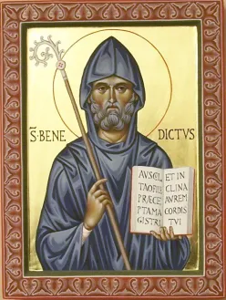 <p>Afgebeeld als Benedictijner abt in een donkere pij met mijter en staf. Vaak draagt hij een (opengeslagen) boek en soms een plak (als teken van discipline). </p>