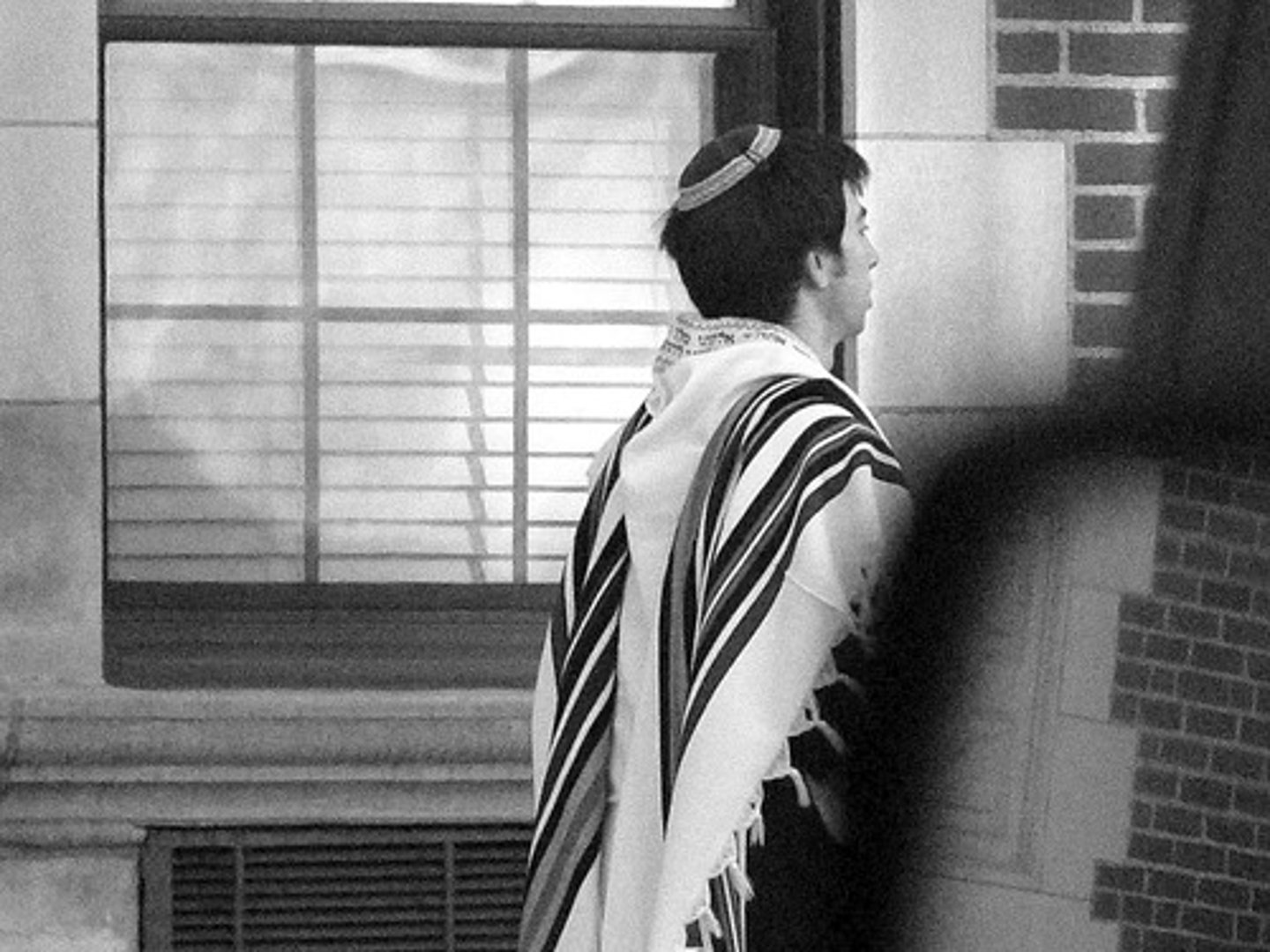 <p>a prayer shawl with fringed edges worn by Jewish males</p>