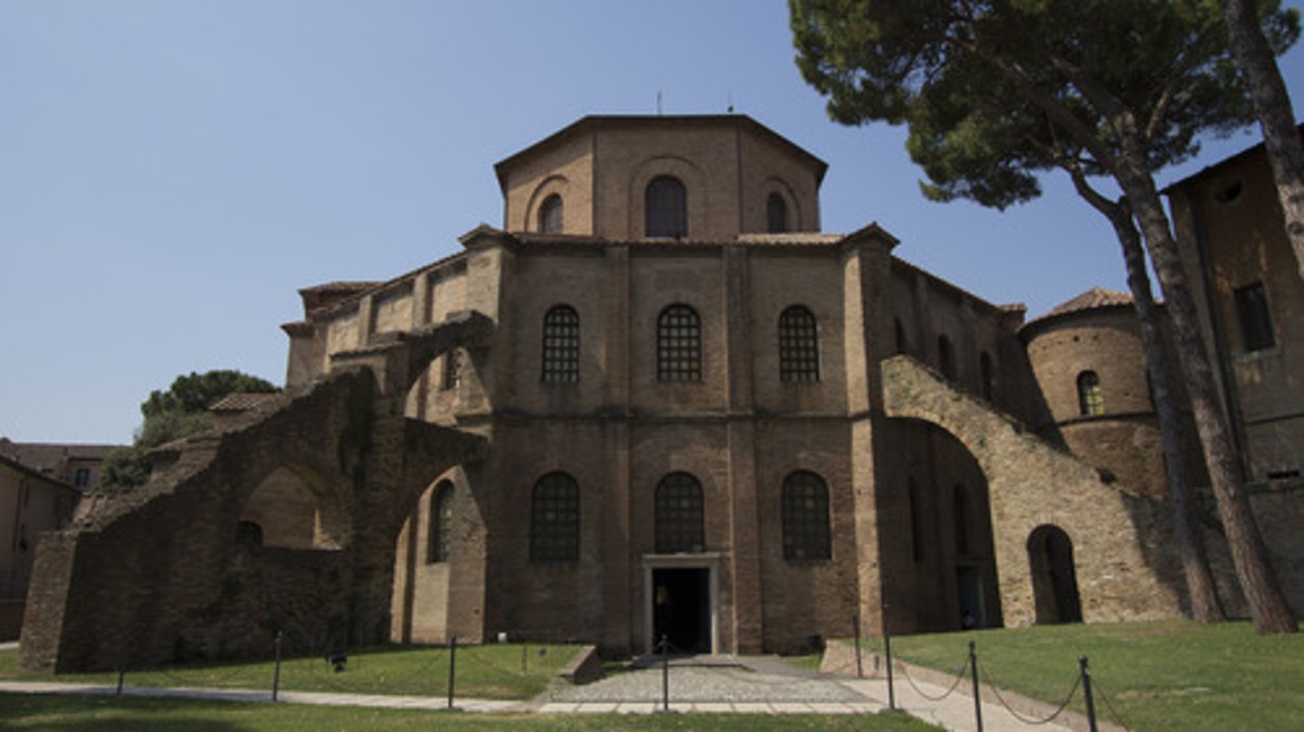 <p>Ravenna, Italy. Early Byzantine Europe. c. 526-547 C.E. Brick, marble, and stone veneer; mosaic.<br><br>Octagonal plan. 2-story ambulatory enclosing central space. Narthex and apse. Mosaics display youthful and clean-shaven Jesus. Romanesque. Ornate interior, plain exterior. Thin columns.</p>