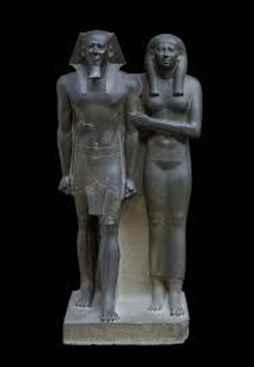 <p>(Giza, Egypt. Old Kingdom, c. 2490–2472 BCE. Greywacke)</p><p>Content: Pharaoh Menkaure and queen (likely Khamerernebty) standing together; idealized, youthful, balanced stance.</p><p>Form: Greywacke sculpture; rigid frontal pose; left foot forward; high relief but attached to block; idealized anatomy; queen shown supporting king.</p><p>Function: Funerary statue from pyramid temple; ensured eternal life and presence of king &amp; queen; reflected divine kingship.</p><p>Context: Old Kingdom art emphasizes permanence, stability, and idealized form; shows role of queen as consort and supporter of king’s rule.</p>