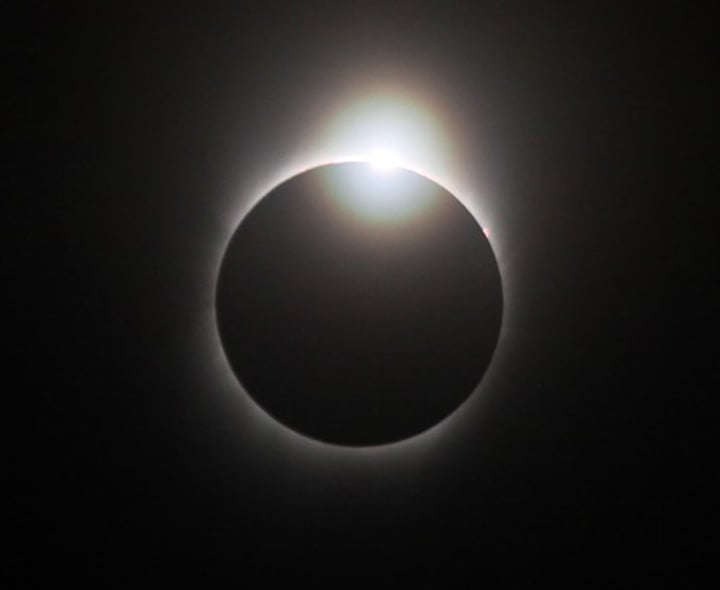 <p>a momentary phenomenon seen during some total solar eclipses when the ring of the corona and a bright spot of photosphere resemble a large diamond set in a silvery ring</p>