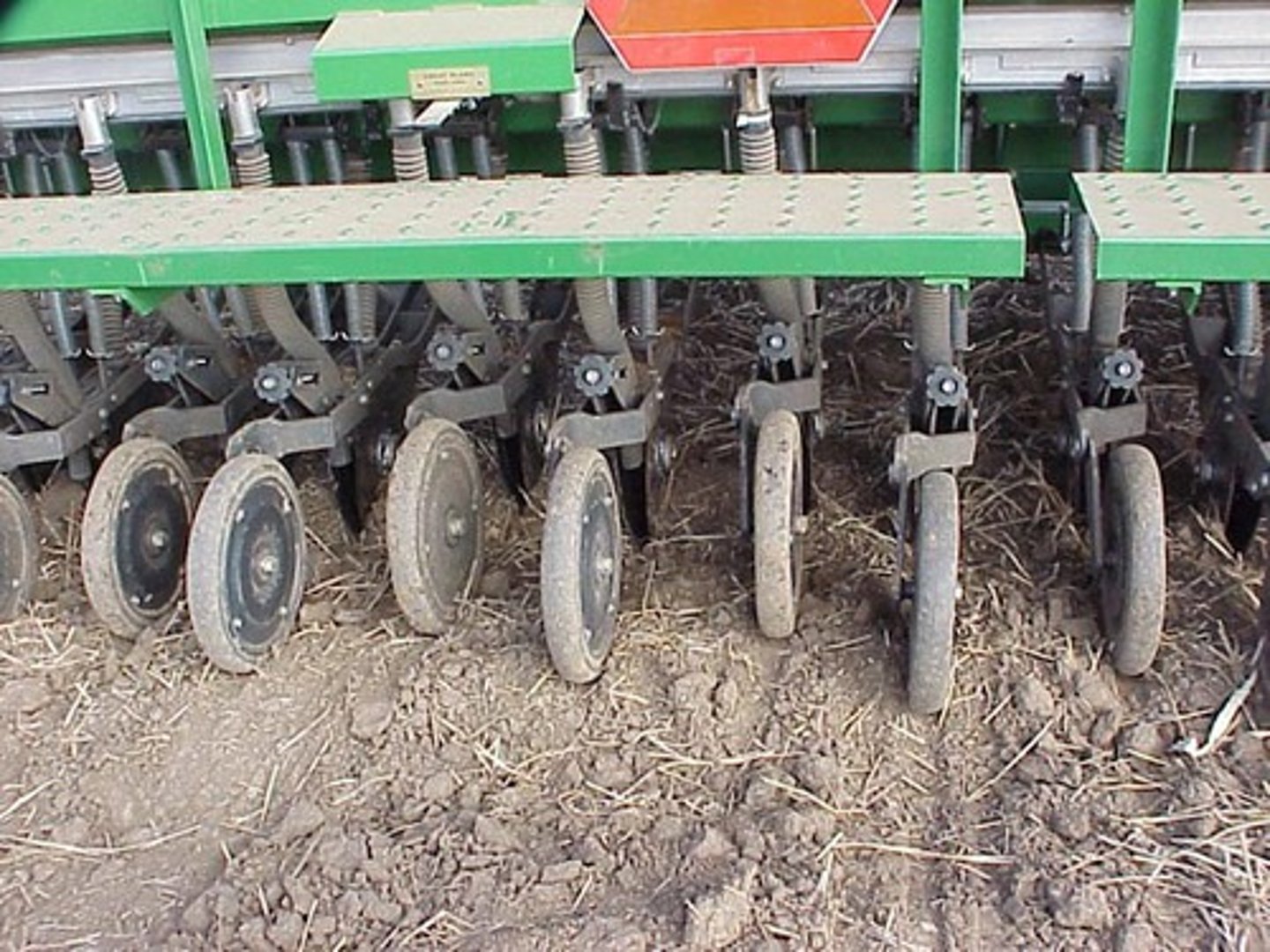 <p>a wheel attachment on an agricultural press drill for compacting the soil in the seeded furrows</p>