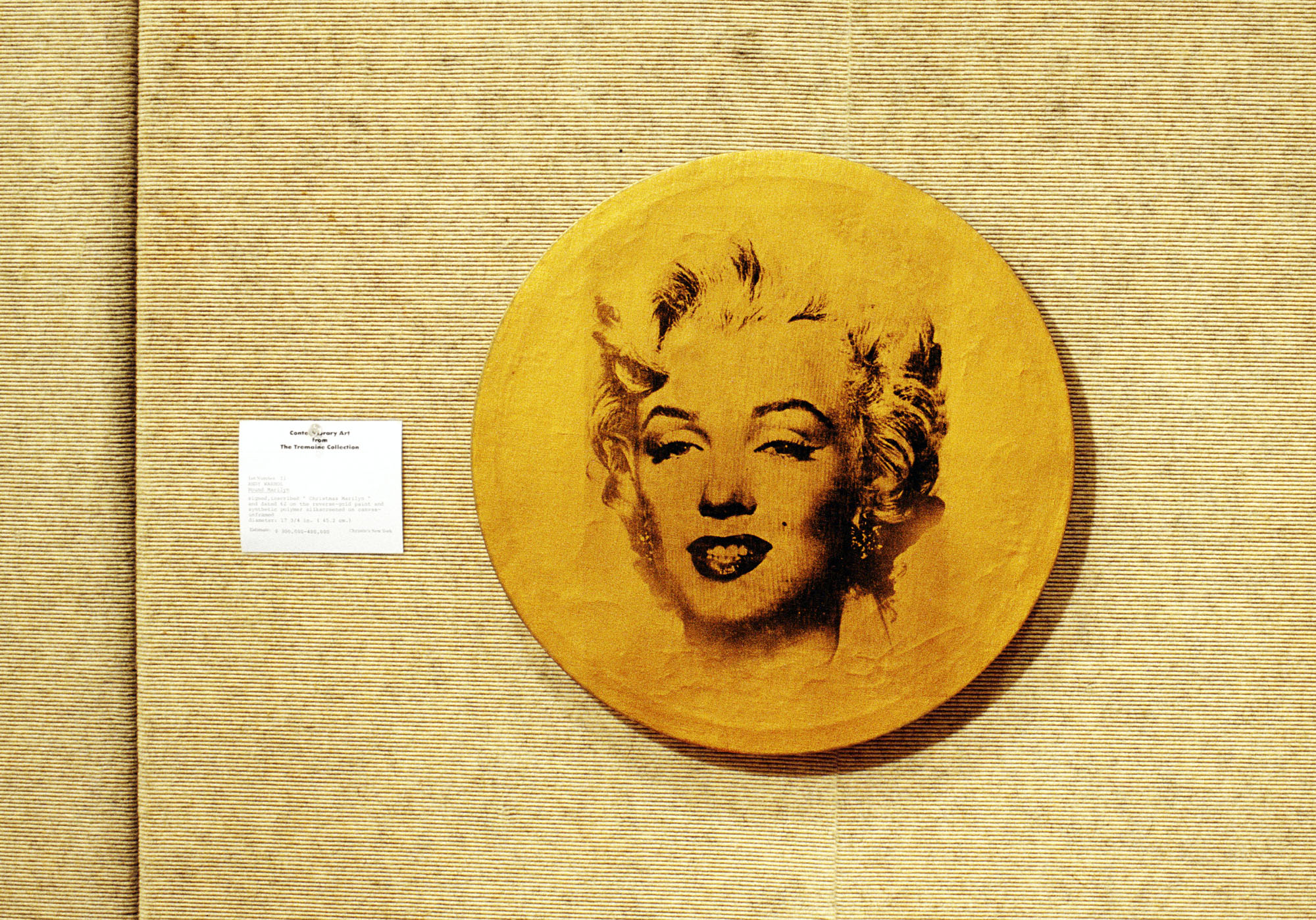 <p>explores the commercialization and commodification of art by presenting Andy Warhol's "Round Marilyn" (1962) in the context of a Christie's auction, with a label asking the titular question.<span>&nbsp;</span></p>