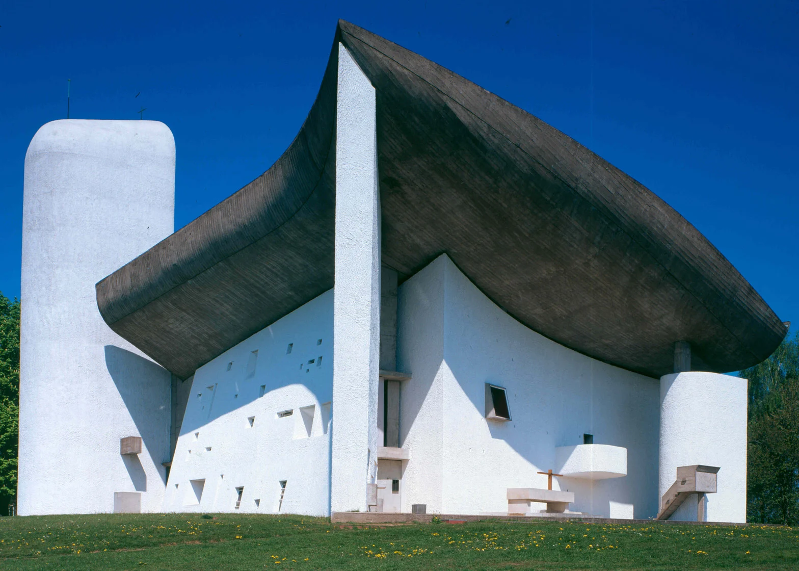 <p>Modernist architecture; a chapel made mostly of concrete and is enclosed by thick walls. The structure was like a sail billowing the windy currents on the hill top</p>