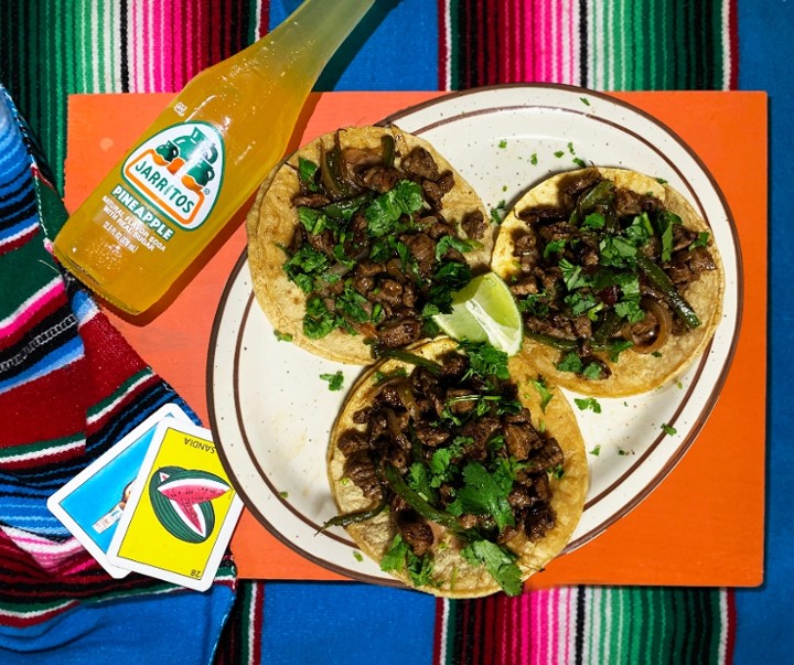 <p>Three tortillas smeared with refried beans, skirt steak, grilled onion and jalapeño peppers, and cilantro. Served with rice and beans.</p>