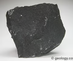 <p>igneous, dominant minerals are plagioclase, pyroxenes, hornblende, olivine. fine-grained texture, dark color, crystals not visible.</p>