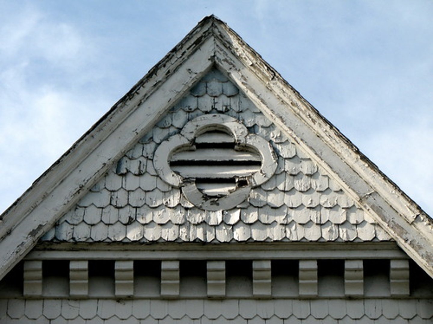 <p>The triangular part of a wall that is enclosed between the sloping portions of a roof.</p>