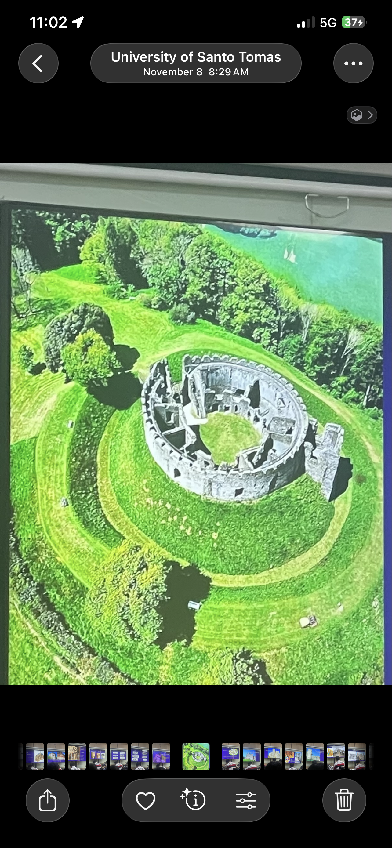 <p>a circular shell of stone wall with various buildings inside it and surrounded by a moat.</p>