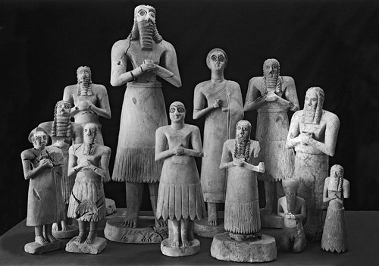 <p>A collection of twelve votive statues, discovered in 1934 at the site of Tell Asmar. They are of men and women with large staring eyes, upturned faces, and clasped hands, dressed in the skirts of the Early Dynastic Period of Mesopotamia.</p>