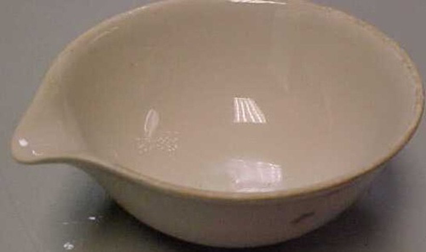 <p>A small ceramic dish in which liquids are heated over a flame so that they evaporate, leaving a solid residue</p>