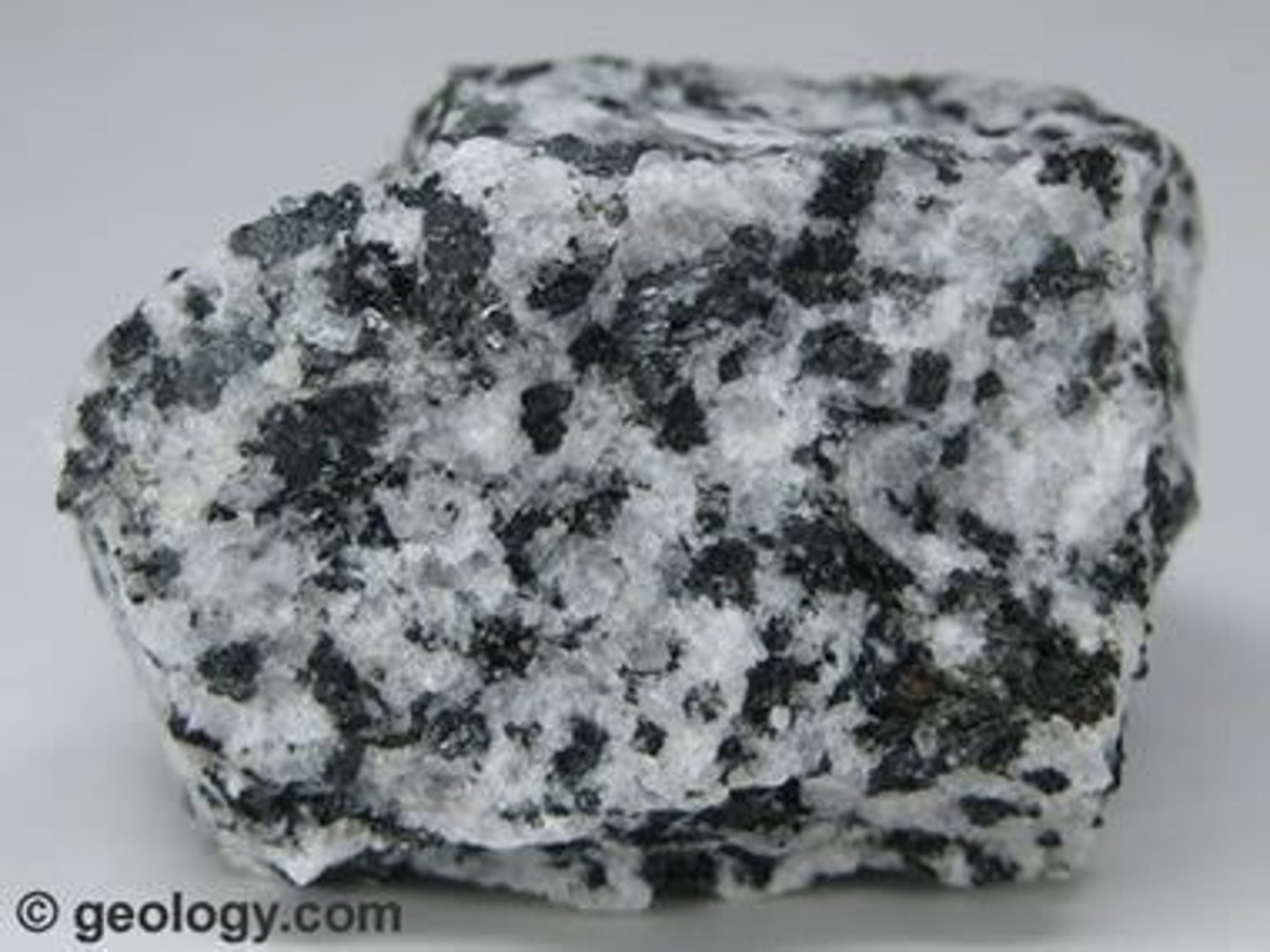 <p>Group of coarse-grained <strong>igneous rocks</strong> with a composition between that of <strong>granite</strong> and <strong>basalt</strong>. It usually occurs as large intrusions, dikes, and sills within continental crust. These often form above a convergent plate boundary where an oceanic plate subducts beneath a continental plate</p>