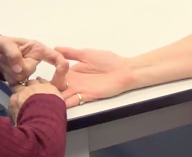 Using one finger on their middle phalanx, apply resistance downwards towards extension