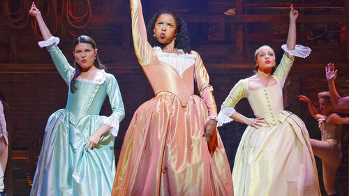 <p>The Schuyler sisters all wear similarly designed dresses with tight bodices and full skirts but in mint green, bright peach and yellow cream respectively. This style of dress hearkens back to women's fashion in the 18th century and suggests a level of elevated social status and formality in their characters.</p>