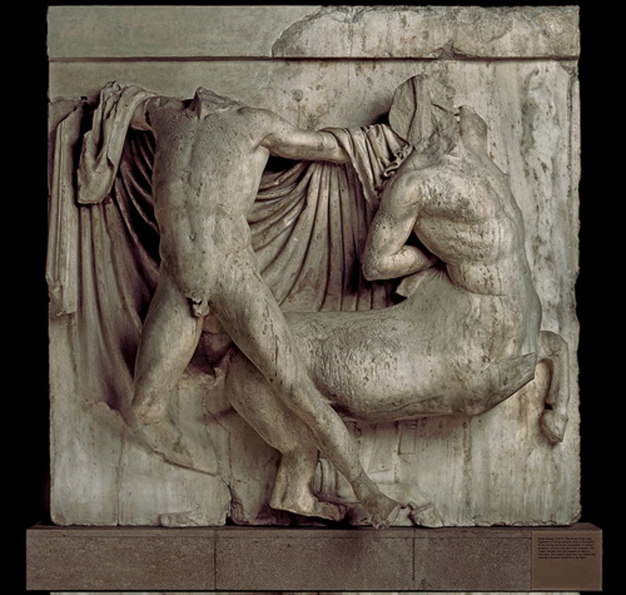 <p>a small relief sculpture on the facade of a Greek temple</p>