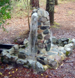 <ul><li><p>Artesian Well is drilled through the ground</p></li><li><p>Confined between two impermeable rock layers which causes a build up of pressure which causes the water to rise on its own</p></li></ul><p></p>