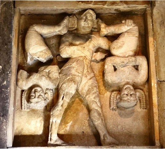 Positioning:

* This metope is between two others, so Hercules’ walking motion guides the viewer to the next metope​
* Metope dominated by vertical lines (hanging Kerkopes and H’s torso)​
* Triangular shape of H’s legs create diversity

Similarities to Pediment of Temple of Artemis, Corcyra:

* Twisted torso with frontal face of Hercules (like Medusa)​
* Framed by: Kerkopes/Panthers​
* Occupation of space​
* Symmetry ​

The Kerkopes:

* Bonds visible on ankles and arms​
* Their hair, arms and faces are carefully sculpted to arrange symmetrical patterns

Archaic Features:

* H face frontal, torso side view​
* Symmetrical composition​
* Mirrored arrangement of Kerkopes frames central figure of Hercules​