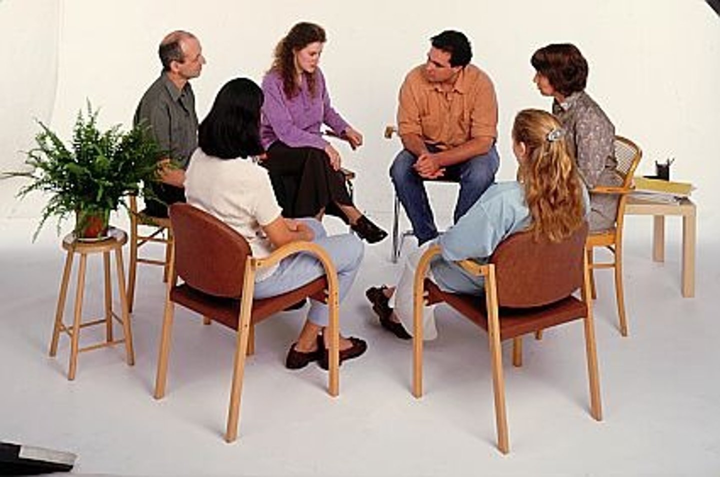 <p>treating several people with similar problems in regular meetings with a trained counselor or therapist</p>