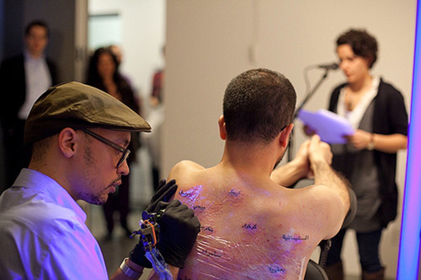 <p>Theme: The Body - Bilal pledged to get over one hundred tattoos on his back, five thousand red dots representing Americans and one hundred thousand dots in UV ink representing the death toll for Iraqis that could only be seen under UV light (representing the underreporting of Iraqi deaths in the US). Visitors were encouraged to read the names of the dead, and Bilal's back was covered at twenty five thousand dots. </p>