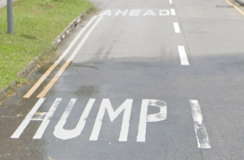 <p>Large letters on road in English, such as hump ahead</p>
