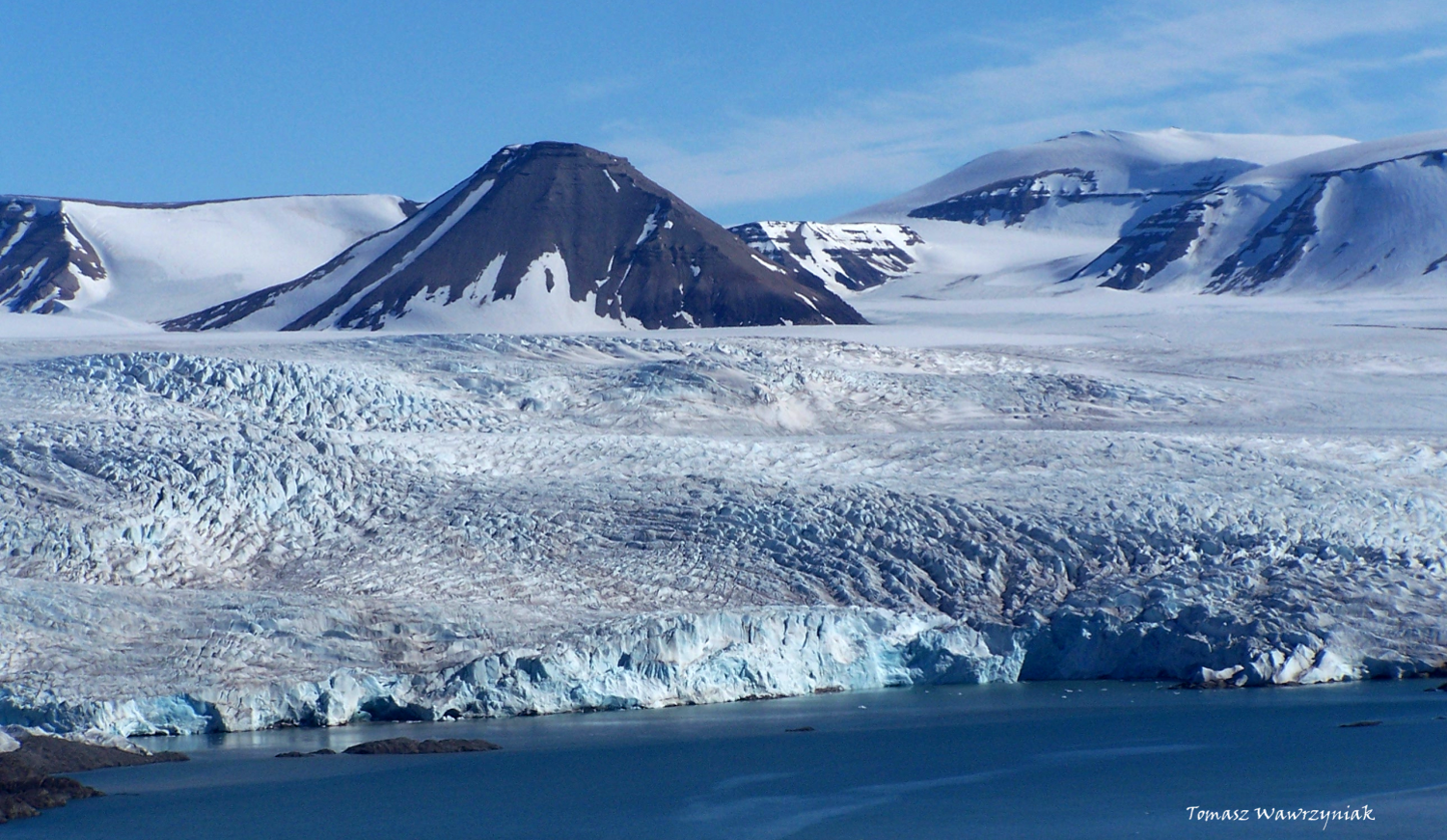 <p>Rocky island surrounded by glacial ice</p>
