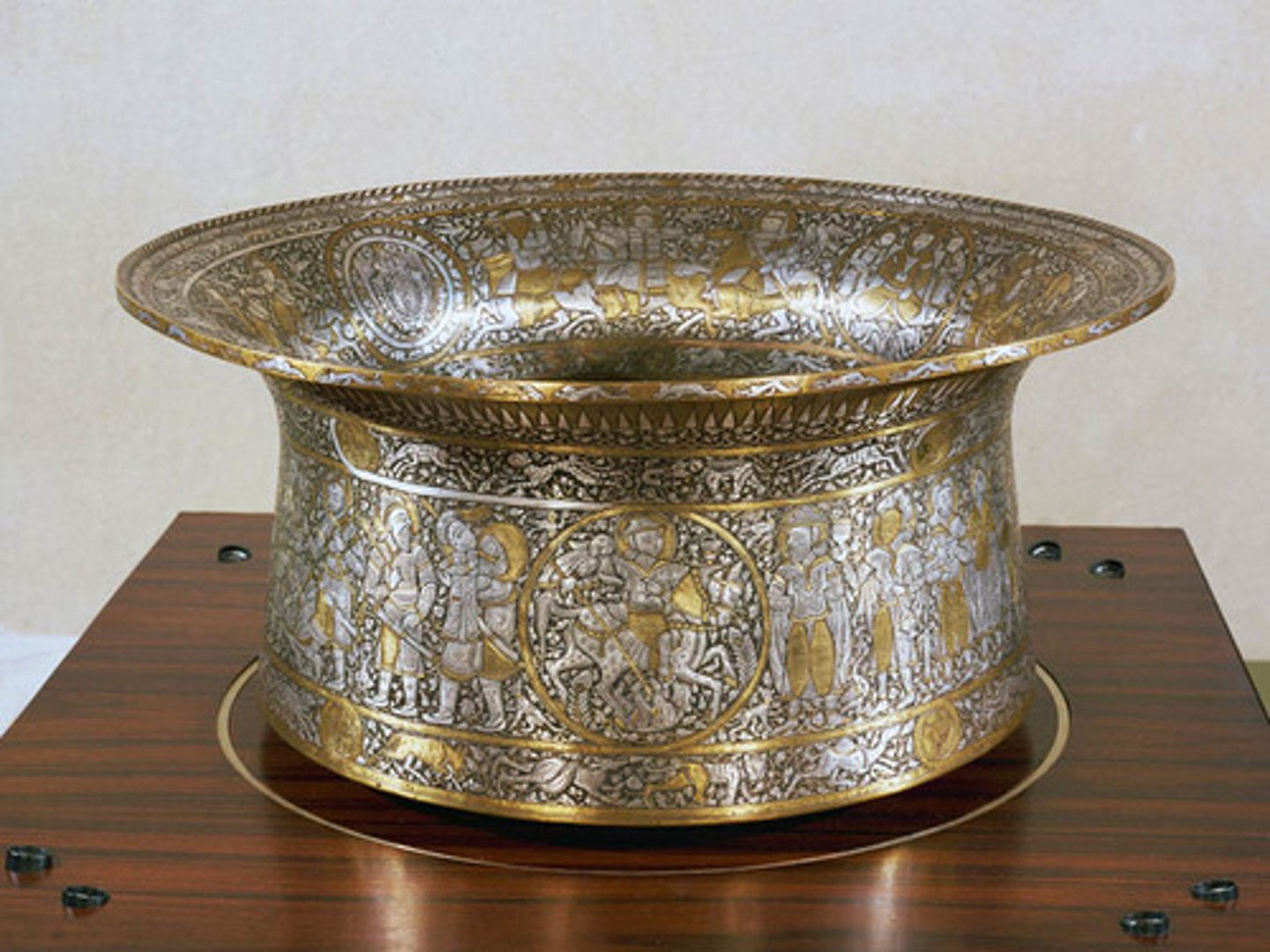 <p>An Islamic brass basin with intricate designs, often associated with the Mamluks, and used for ceremonial purposes/ Later used as a christening basin for Louis XIV(one of the Louis)</p>