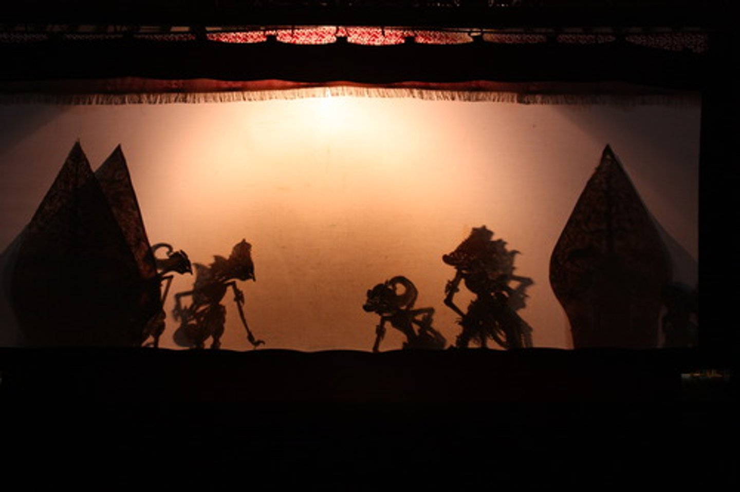 <p>A kayon is a fan/tree shaped shadow figure of an Indonesian wayang kulit performances. They are made from punctured buffalo hide. It represents the universe in a tree and is used to frame the play in the beginning and end.</p>