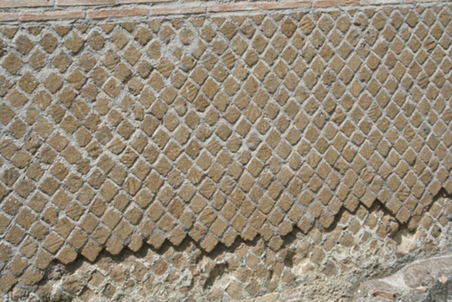 <p>An ancient Roman masonry wall faced with small pyramidal stones set diagonally with their square bases forming a netlike pattern.</p>