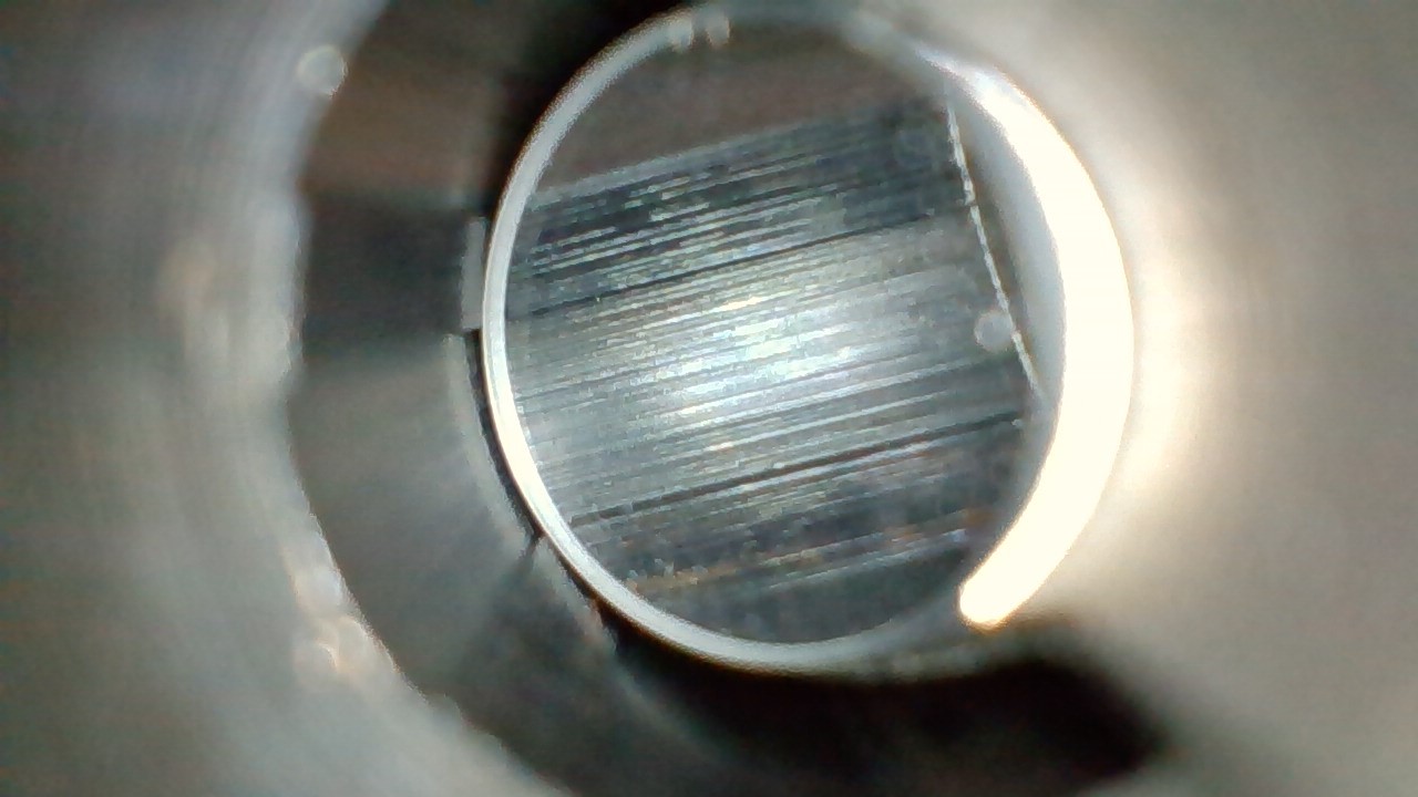 <p>What type of machining likely created the continuous lines running parallel to the rifling (in the lands and grooves) seen in this barrel?</p>