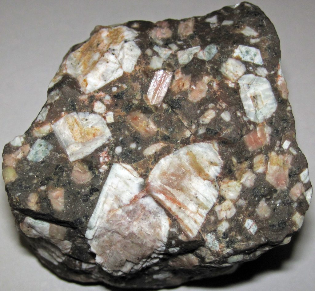 <p>Porphyritic- bimodal grain size distribution.</p><p class="MsoNormal">Rock can have two dominant grain sizes. The larger crystals are called phenocrysts, and the finer crystals are called groundmass. In volcanic porphyritic rocks the ground mass is aphanitic.</p><p class="MsoNormal">They indicate a two-stage cooling process where larger crystals formed first followed by the rapid cooling of the remaining magma, making it most commonly observed in volcanic igneous rocks as they often experience this rapid cooling at the earth’s surface after a period of slower crystallization deep within the crust.</p>