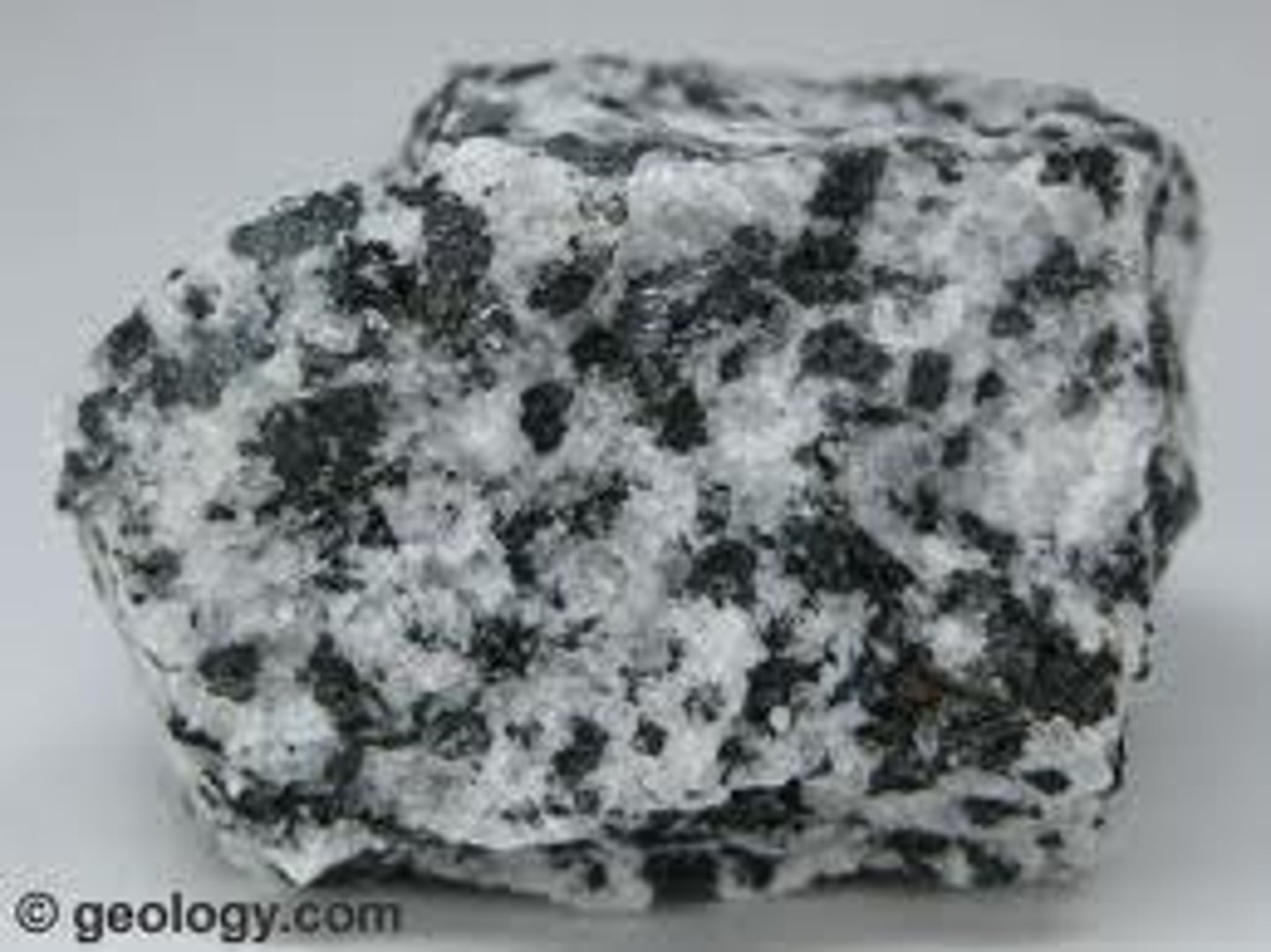 <p>Rock formed from the cooling and solidification of magma beneath Earth's surface. Coarse grained (large minerals, see image), and long cooling time.</p>